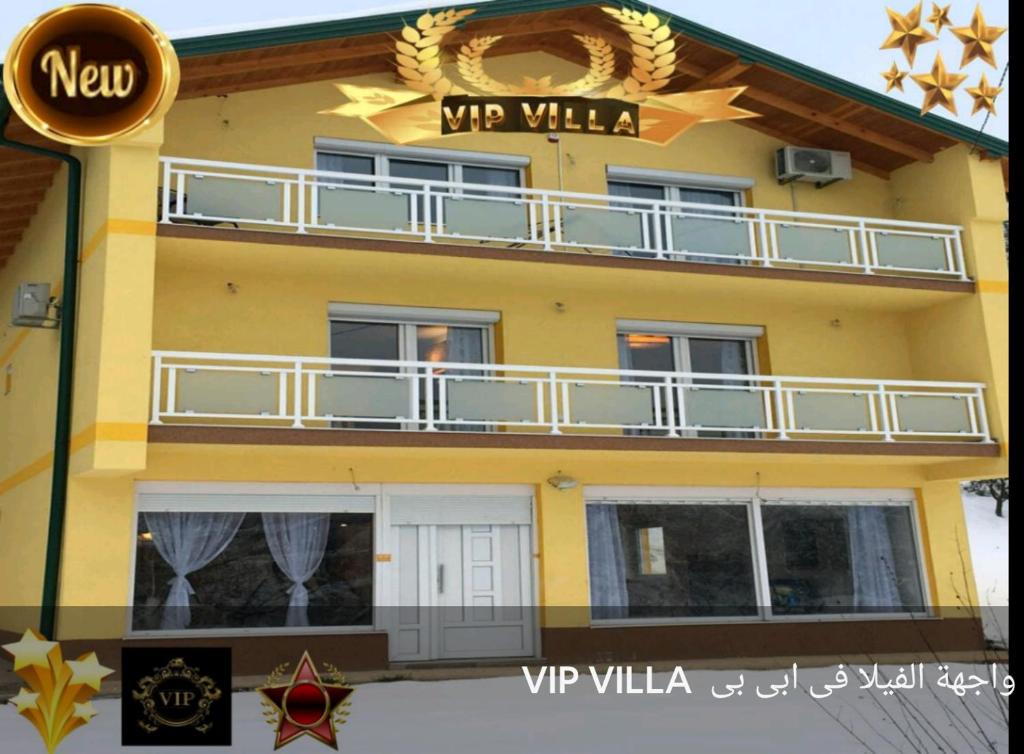 ein gelbes Gebäude mit einem Balkon und einem Schild darauf in der Unterkunft Vip villa فيلا في اي بي in Sarajevo