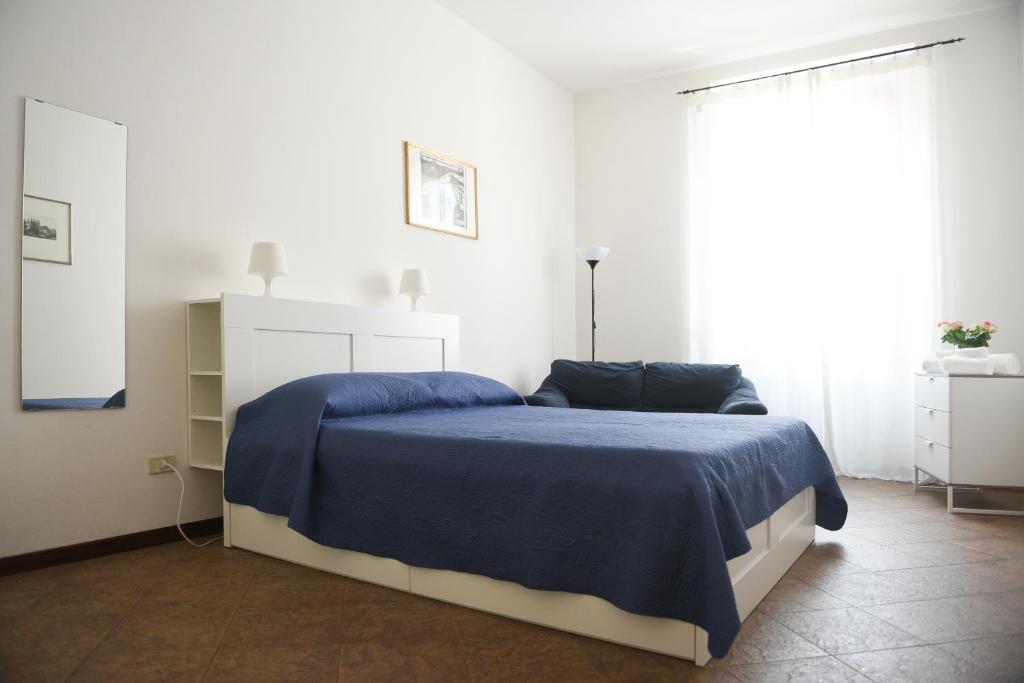 una camera bianca con un letto con una coperta blu di "Il Ponte" Apartment in Florence a Firenze