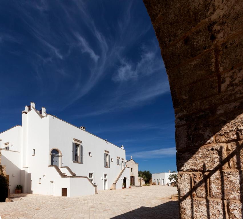 a white building with stairs on the side at Masseria Borgo Mortella in Lecce