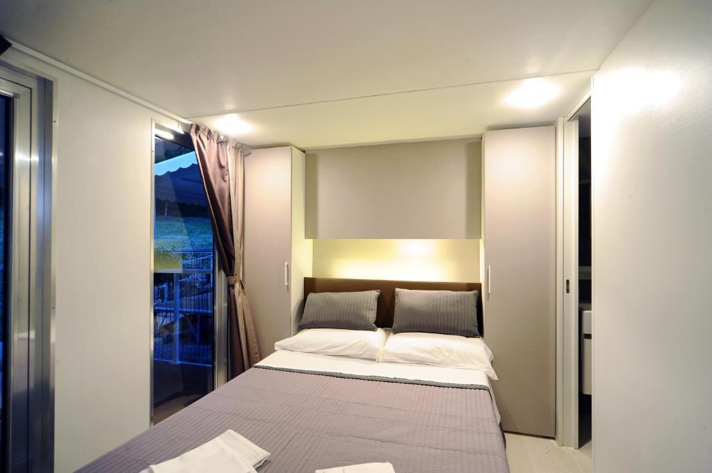 ein kleines Schlafzimmer mit einem Bett und einem Fenster in der Unterkunft Parco delle Piscine in Sarteano