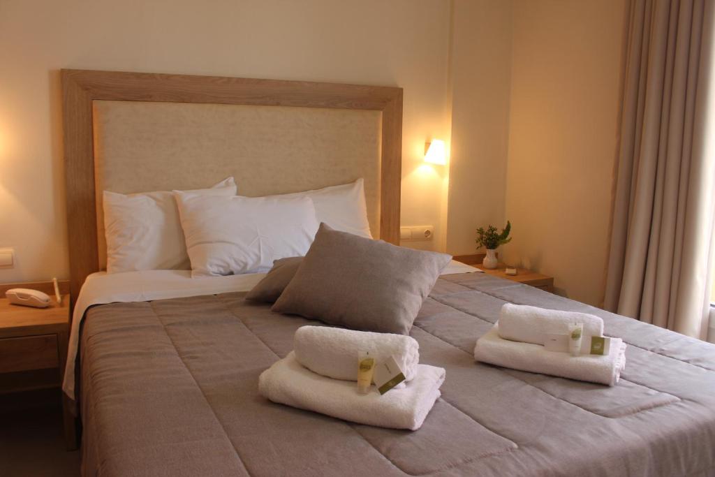 a bedroom with a large bed with towels on it at Kristi Apartments in Hersonissos
