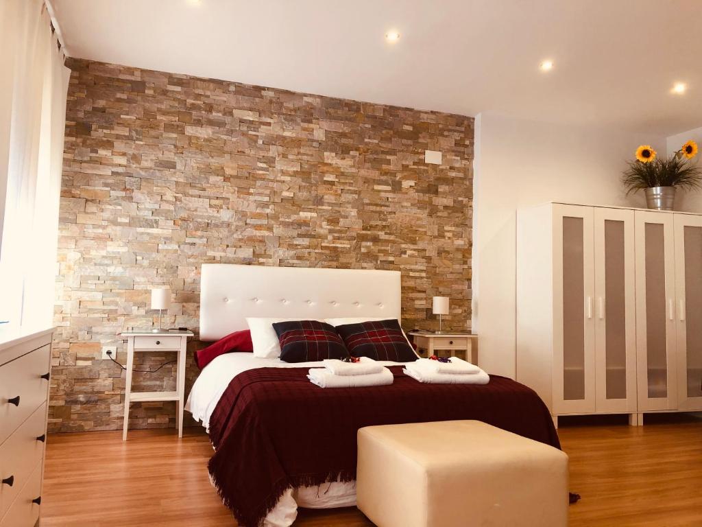 阿奇多納的住宿－LA VICTORIA 1 El Paseo，一间卧室设有一张带砖墙的大床