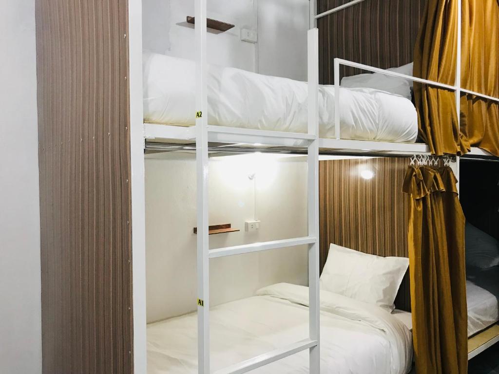 a room with three bunk beds with a bed at Naga Hostel & Café in Thakhek