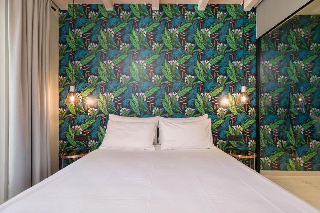 a bed in a room with a wall with plants at Agave Boutique Hotel in Laganas
