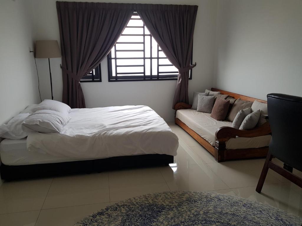 1 dormitorio con cama, sofá y ventana en The Executive Seaview 1 at Icon Residence, en Kuala Terengganu