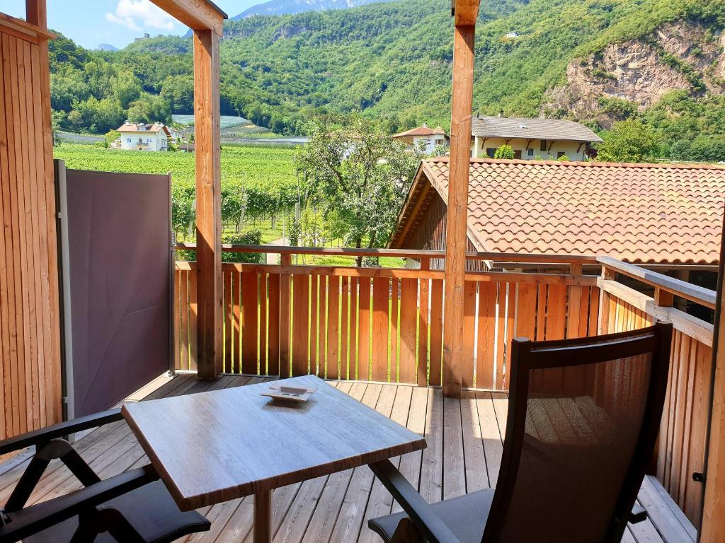 a wooden porch with a table and two chairs on it at Versigglhof in Appiano sulla Strada del Vino
