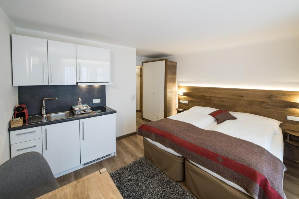 a bedroom with a bed and a sink at Apartments Butterfly Zermatt in Zermatt