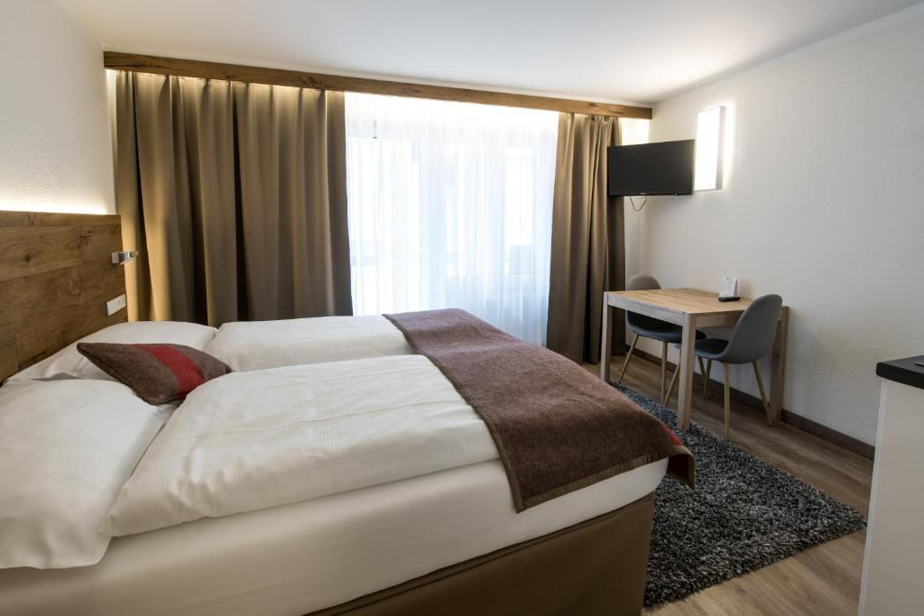 a hotel room with a bed and a desk at Apartments Butterfly Zermatt in Zermatt