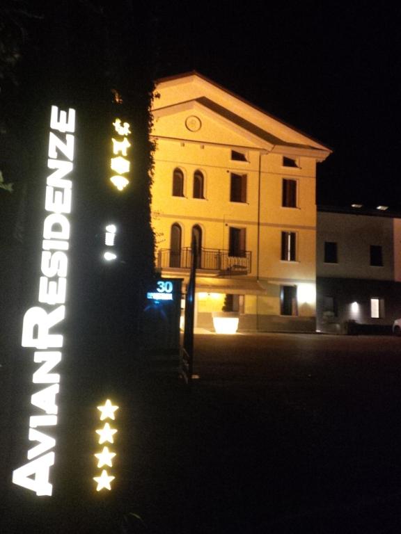 a hotel sign in front of a building at night at AvianResidenze in Aviano