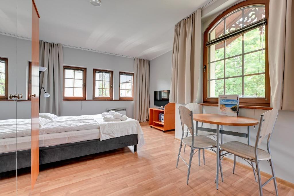 1 dormitorio con 1 cama, mesa y sillas en Dom & House - Apartamenty Zacisze, en Sopot