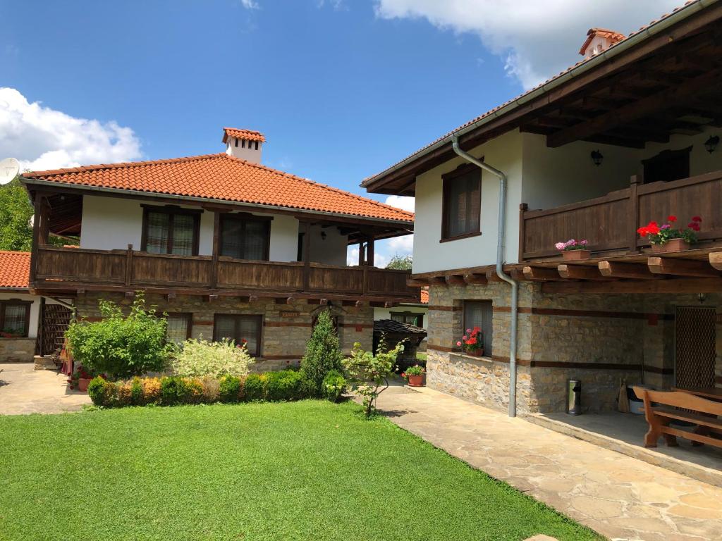 a house with a bench next to a yard at Baba Stana Houses in Apriltsi