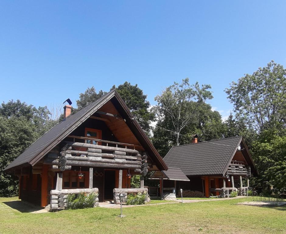 uma cabana de madeira com um telhado de gambrel em ŠMITI em (( Čūskumuiža ))
