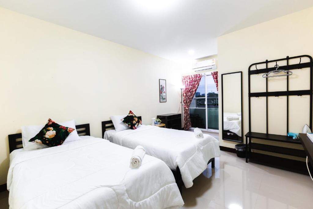 A twin room with balcony access, open storage, and a full-length mirror.