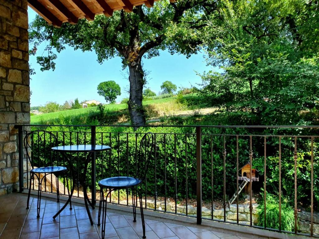 a balcony with two tables and a tree at Residenze l'Alberata in Collazzone