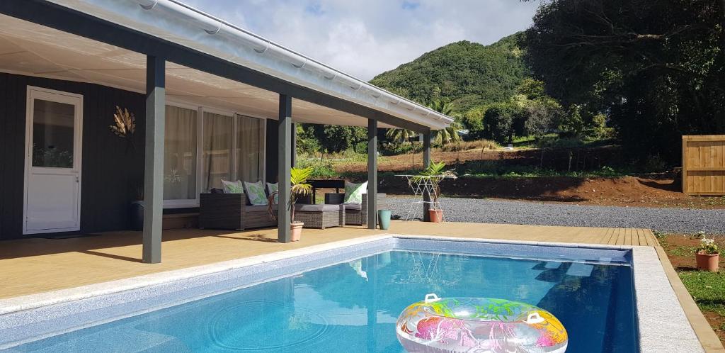 a swimming pool with a toy in front of a house at Te Etu Villa 2 in Rarotonga