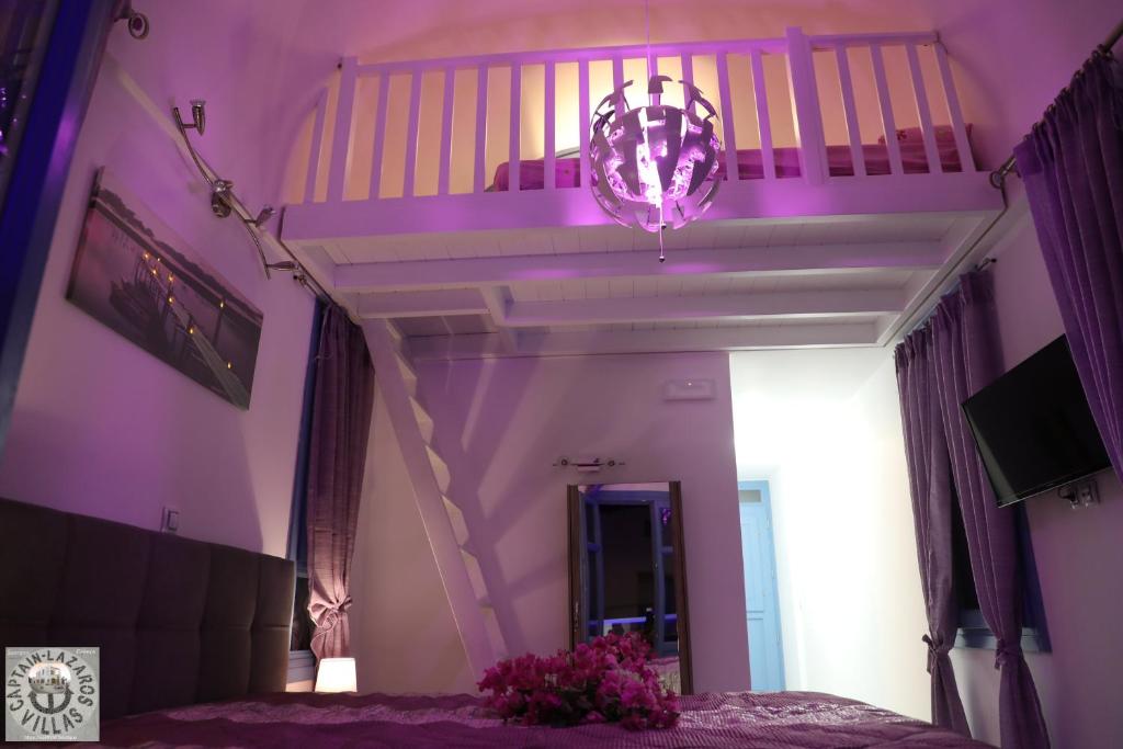 Fioletowa sypialnia z łóżkiem i schodami w obiekcie Located by the sea one beachfront Private Captain Lazaros Pool Villa with loft in 750sqm spacious private plot-Jacuzzi-sunrelax-furnished terace-gazebo-private parking,sleep 3 adults and 2 children, just steps from the Black Beach-Seaview w mieście Perissa