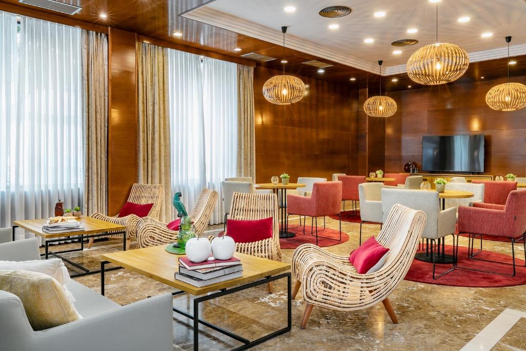 un hall avec des tables et des chaises ainsi qu'un restaurant dans l'établissement Vincci Ciudad de Salamanca, à Salamanque