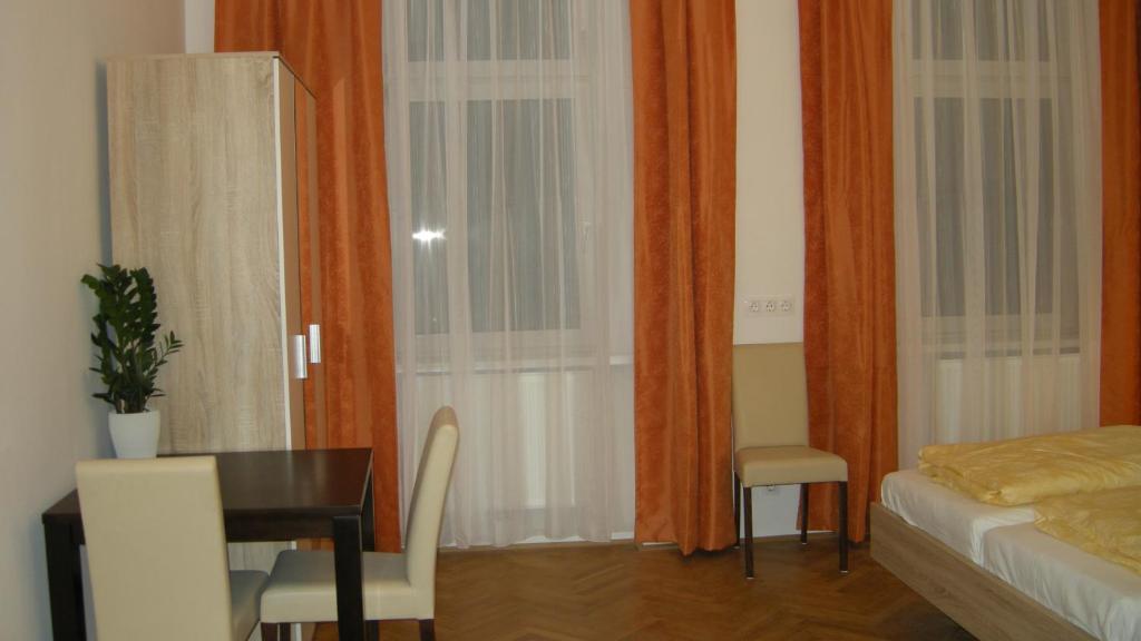 1 dormitorio con escritorio, mesa y cama en Appartements CHE, en Viena