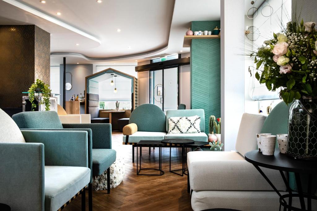 a waiting room with blue chairs and tables at Hôtel Eiffel Saint Charles in Paris