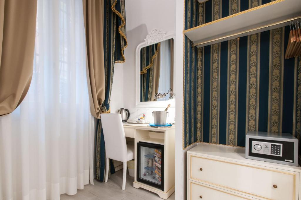 Cette chambre comprend un bureau et une chaise à côté d'une fenêtre. dans l'établissement Al Mascaron Ridente, à Venise