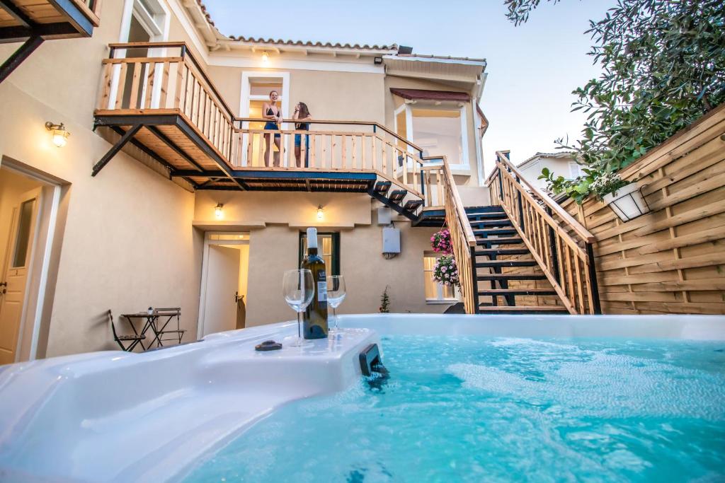 a hot tub in front of a house with stairs at Levkosh Apartments at Lefkada's Heart in Lefkada Town