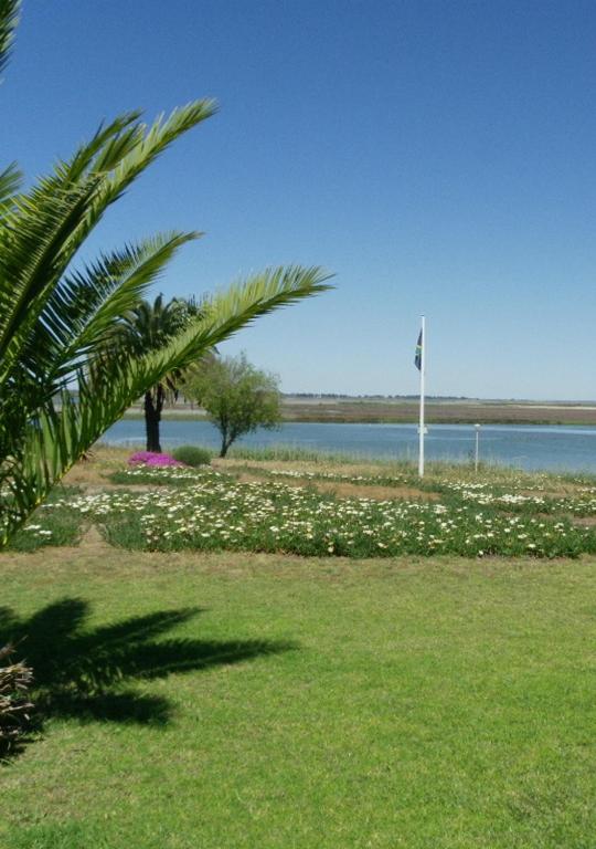 a park with a flag and a body of water at Kingfisher by the river - self catering in Velddrif