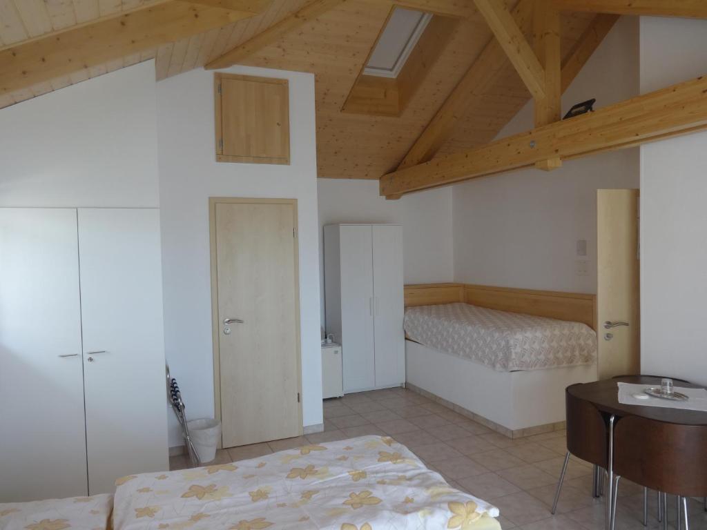 a bedroom with two beds and a table in a room at Bed and Breakfast Prilly-Lausanne in Prilly