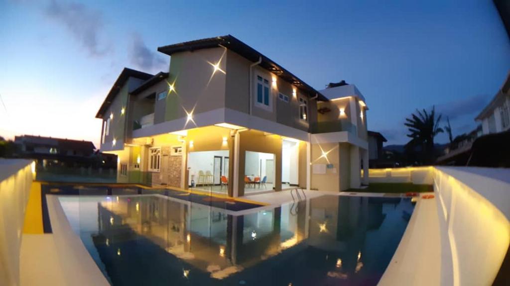 a house with a swimming pool in front of a house at Sunshine Lodge in Kuantan