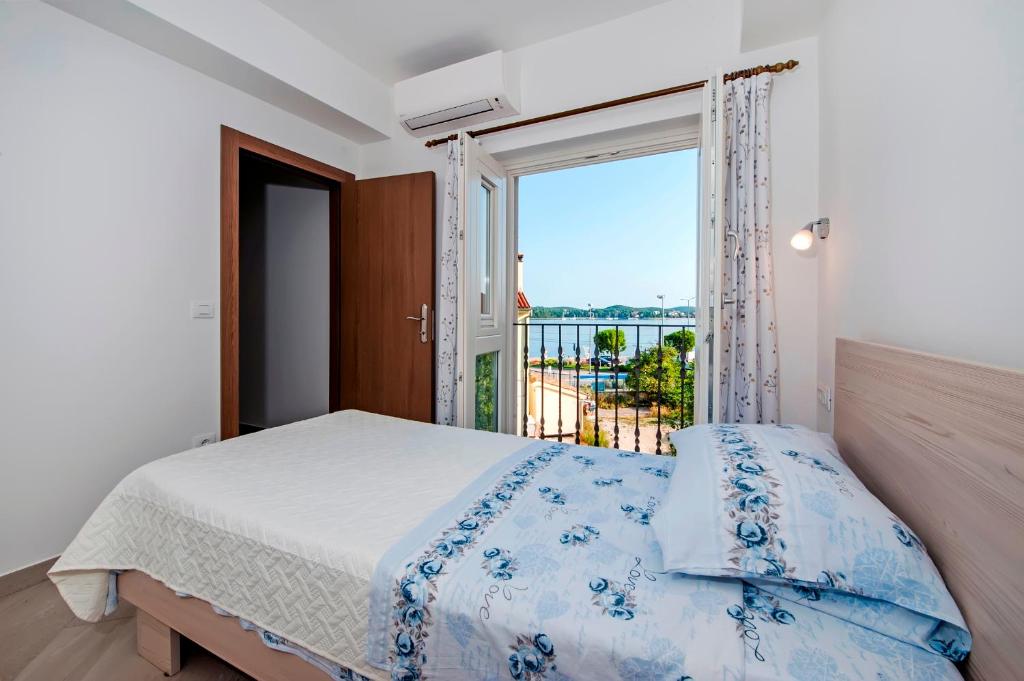 een slaapkamer met een bed en een groot raam bij Casa Campus in Rovinj