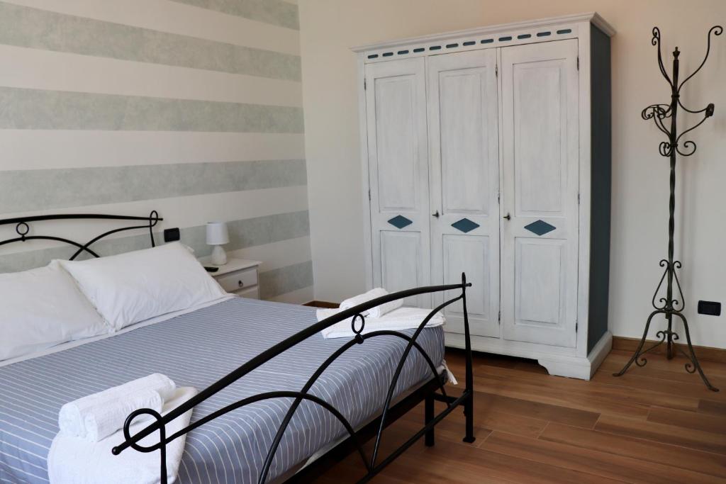 1 dormitorio con 1 cama y armario blanco en Casa vacanze Beach House vicino alla stazione en La Spezia