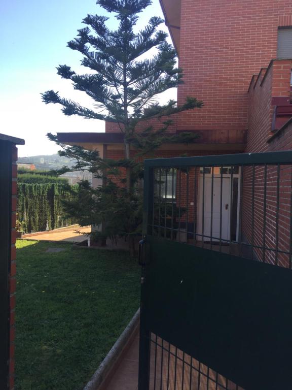 a gate with a tree in front of a building at Espacio tipo estudio completo, totalmente privado e independiente in Erandio