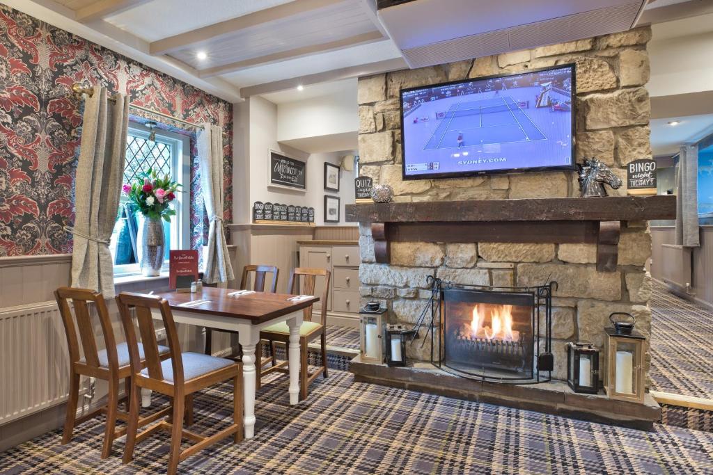 a living room with a table and a fireplace at West Port Hotel in Linlithgow