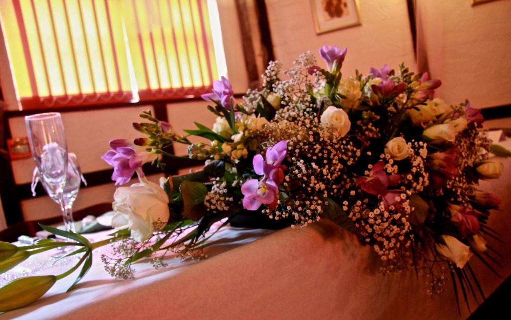 a table with a bouquet of flowers on it at The Horse and Groom in Swaffham