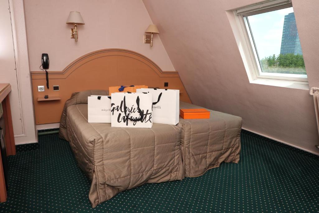 een bed in een kamer met borden erop bij Hotel Des Arenes in Parijs