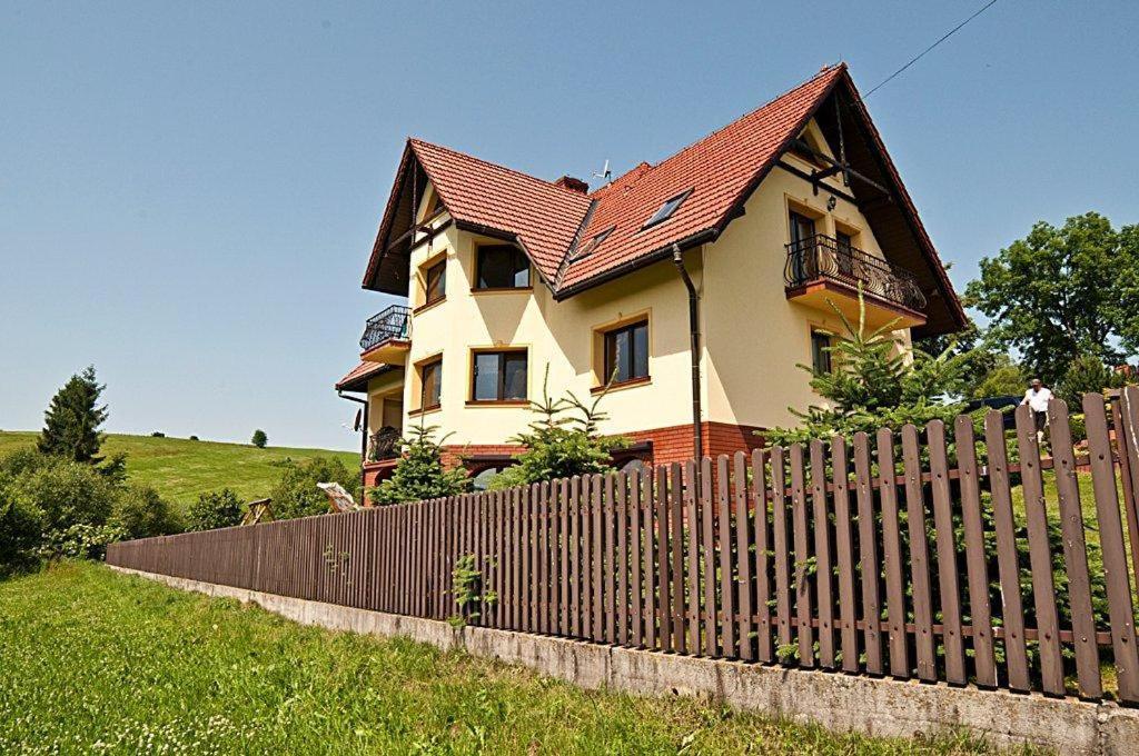 a house with a wooden fence in front of it at Willa ,, Krokus" in Ciche