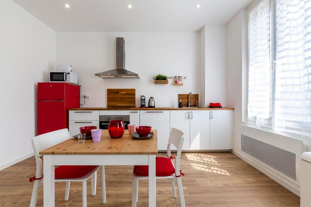 - une cuisine avec une table en bois et un réfrigérateur rouge dans l'établissement MISIRLOU -Superbe Studio dans la Vieille Ville, à Marseille