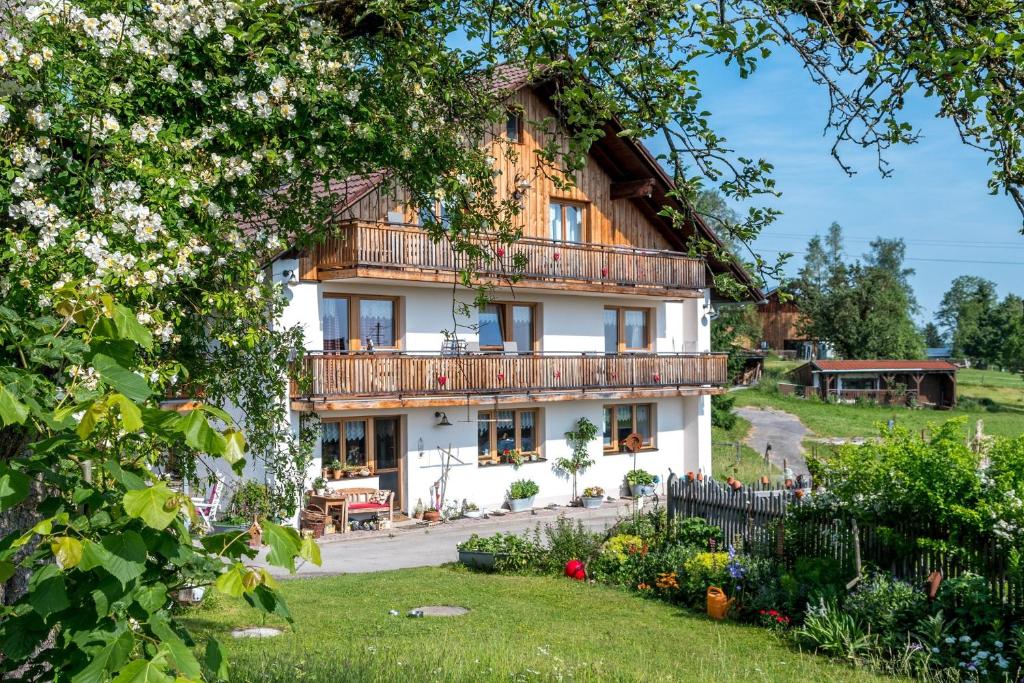 une maison avec un balcon et un jardin dans l'établissement Ferienhof Am Holderbusch, à Füssen