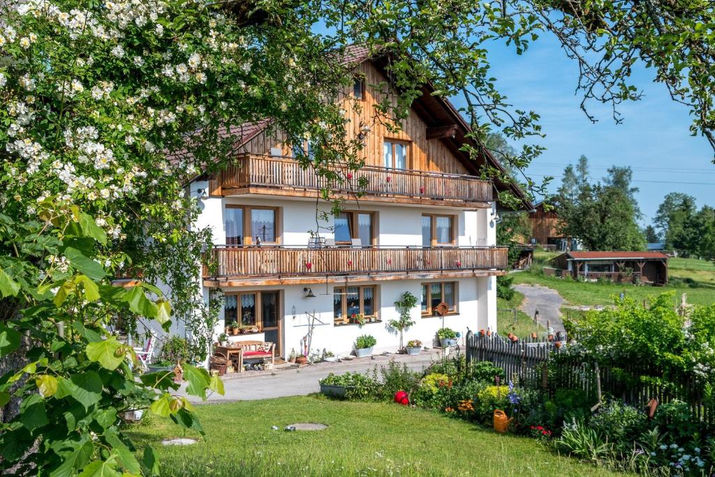 a house with a balcony and a garden at Ferienhof Am Holderbusch in Füssen