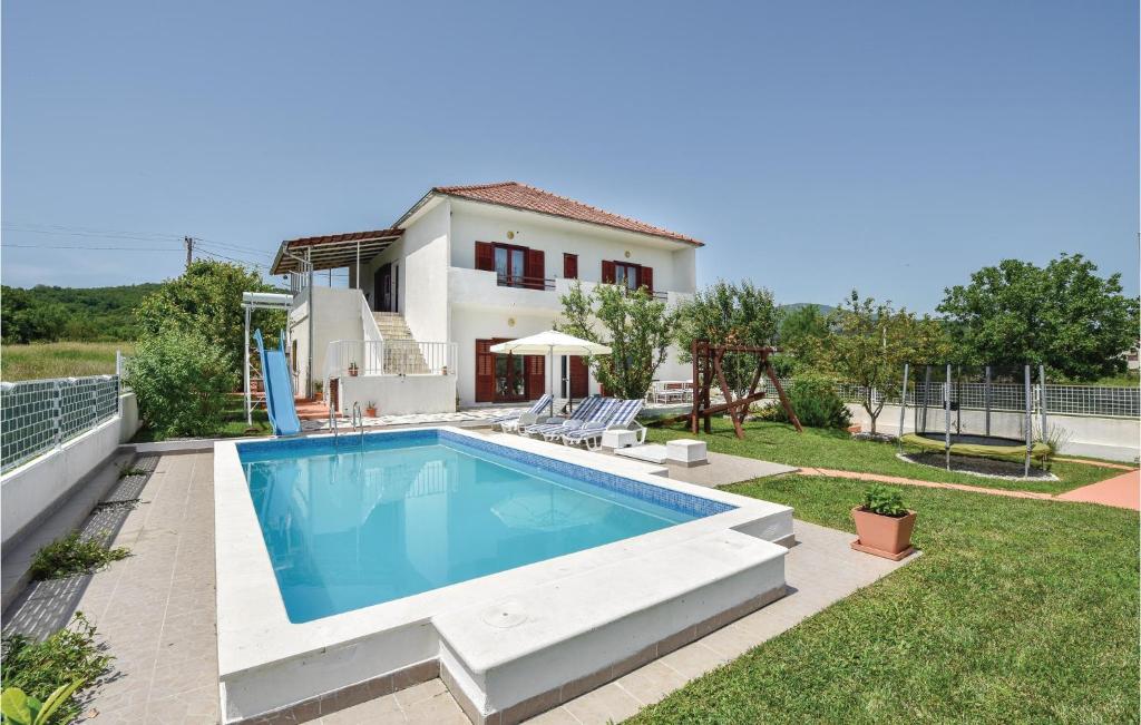 a villa with a swimming pool and a house at Stunning Home In Sinj With 3 Bedrooms, Wifi And Outdoor Swimming Pool in Rožani