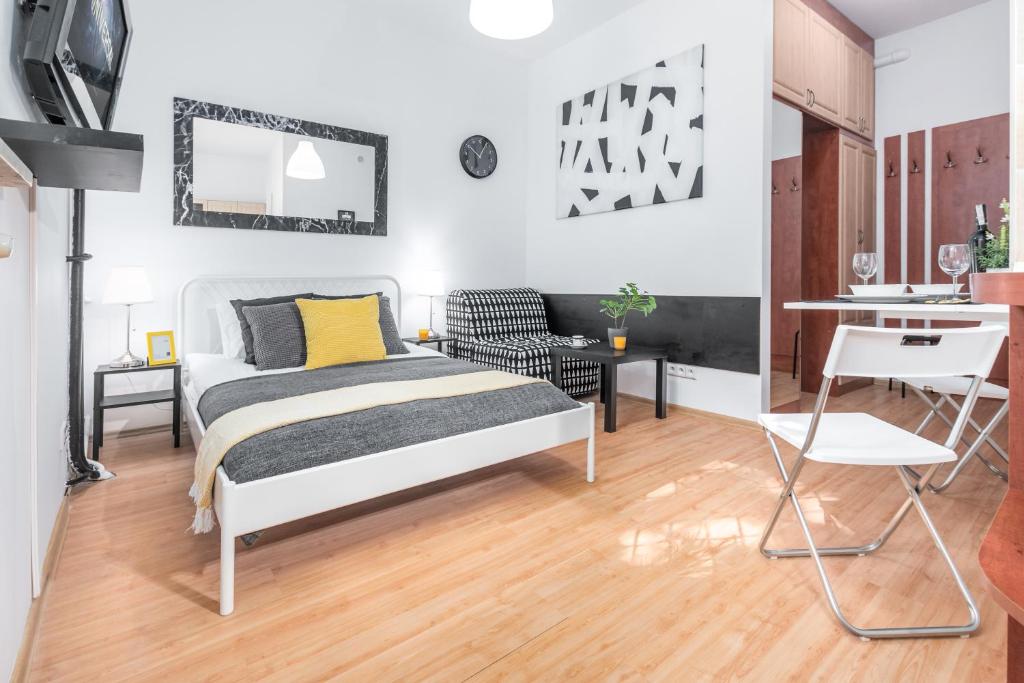 sypialnia z łóżkiem i biurkiem oraz kuchnią w obiekcie Apartments Wilcza 55 by Noclegi Renters w Warszawie
