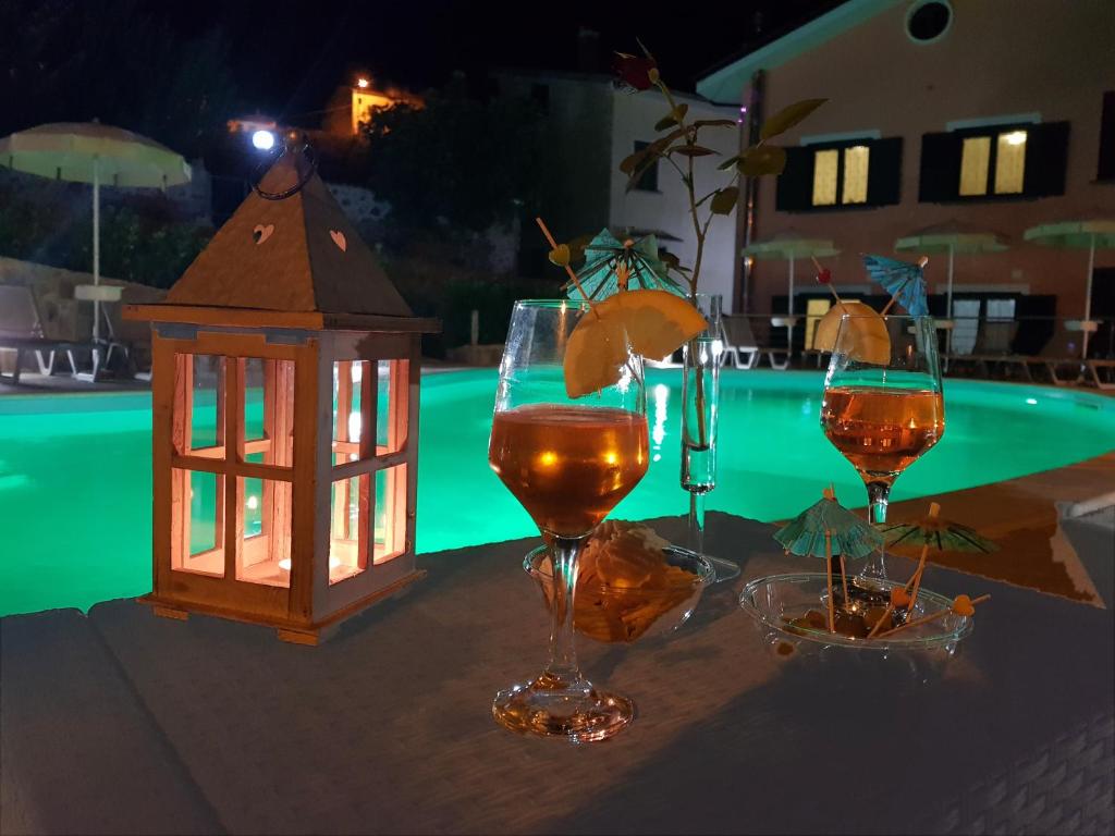 een tafel met twee glazen wijn en een lantaarn bij Residence Gli Ulivi di Eolo in Sapri