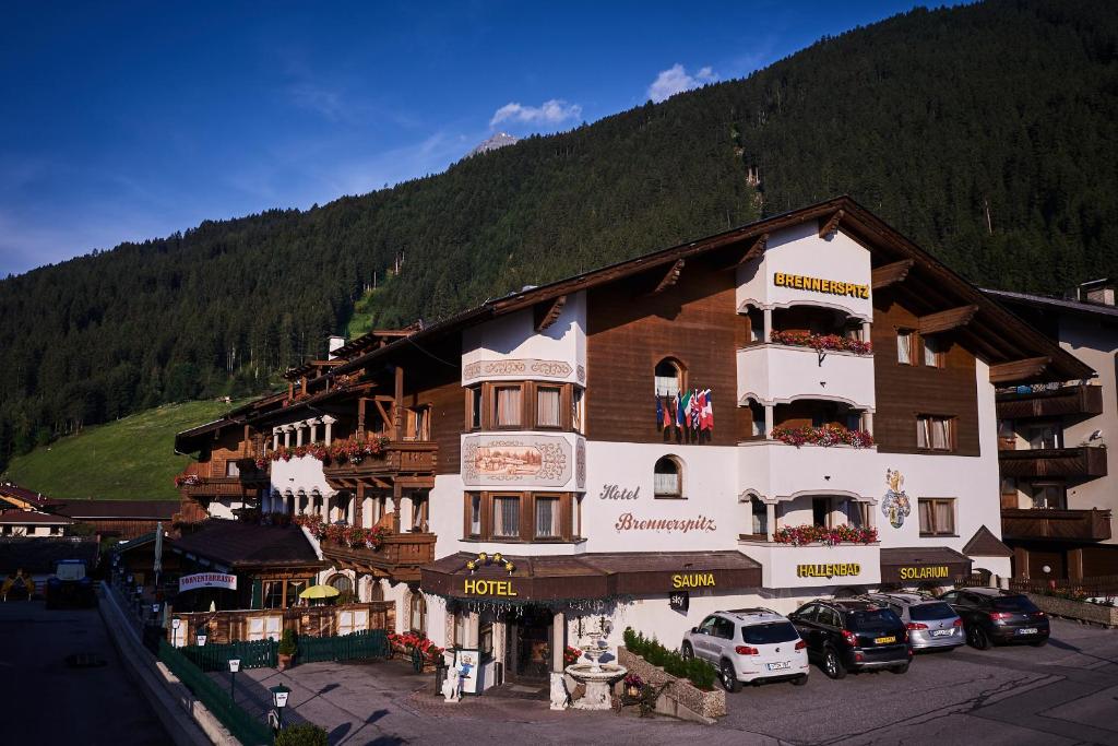 a large building with cars parked in front of it at Hotel Brennerspitz in Neustift im Stubaital