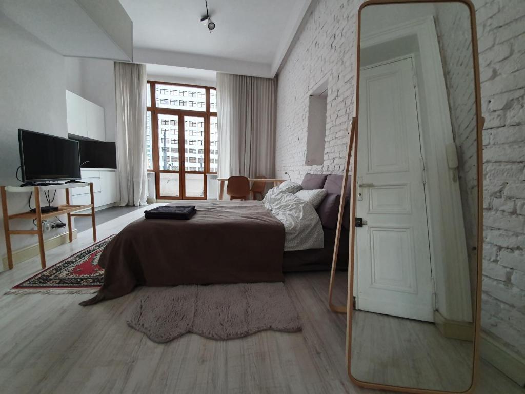 - une chambre avec un lit et un miroir dans l'établissement Prawdopodobnie najlepsze miejsce przy OFF Piotrkowska, à Łódź
