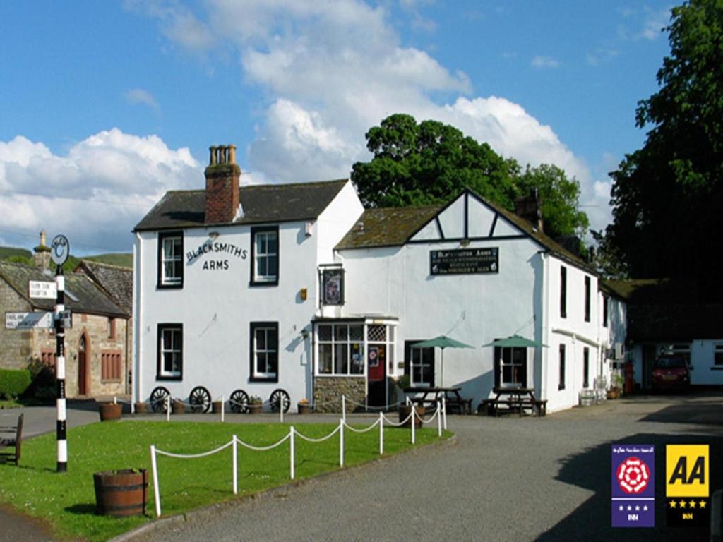 un gran edificio blanco con un cartel delante en The Blacksmiths Arms, en Brampton