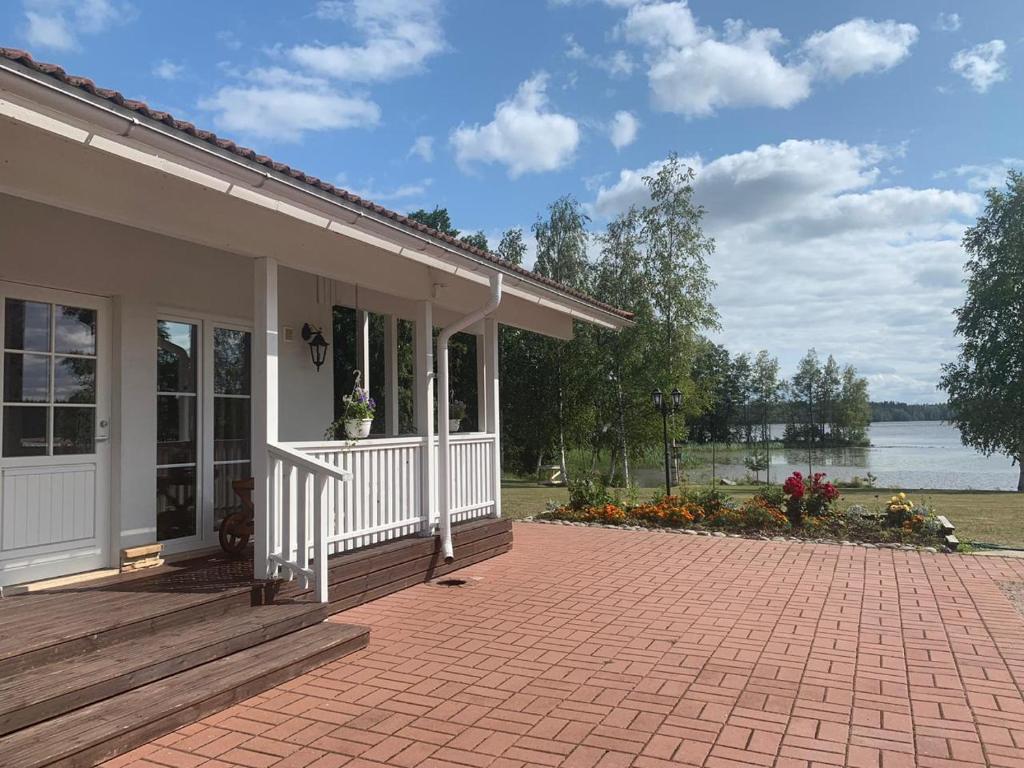 a house with a porch and a brick patio at Wonderful cottage by the lake in Hautjärvi