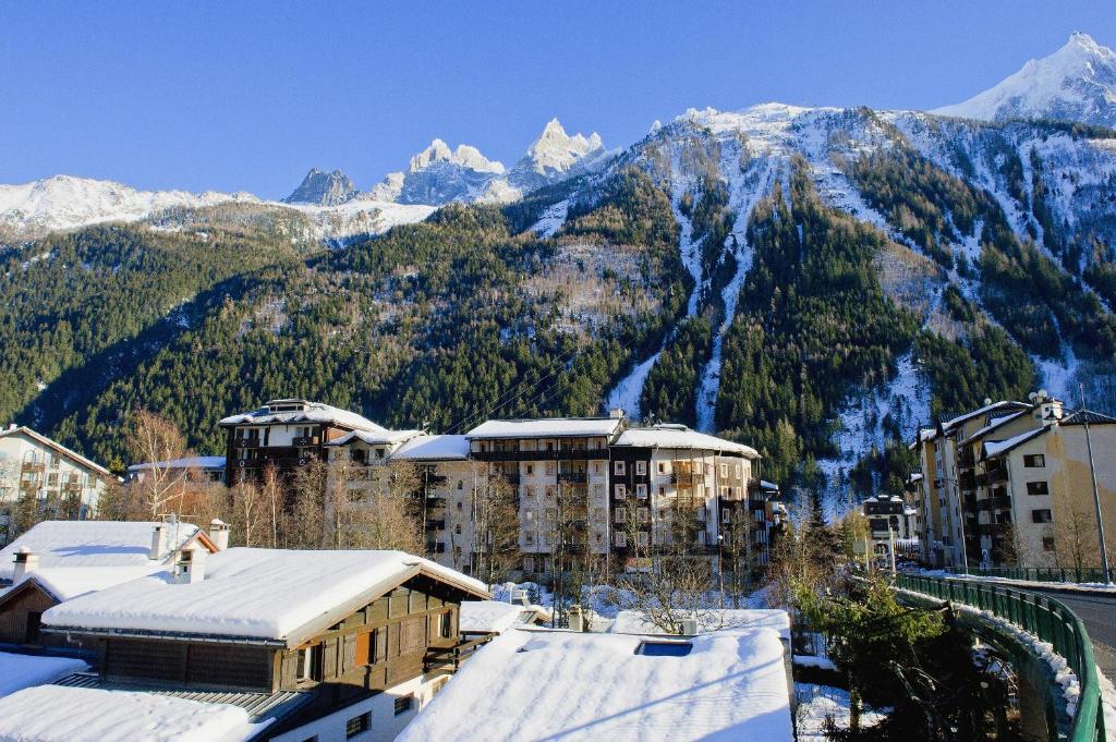 une ville avec des montagnes enneigées en arrière-plan dans l'établissement maeva Home Résidence la Rivière, à Chamonix-Mont-Blanc