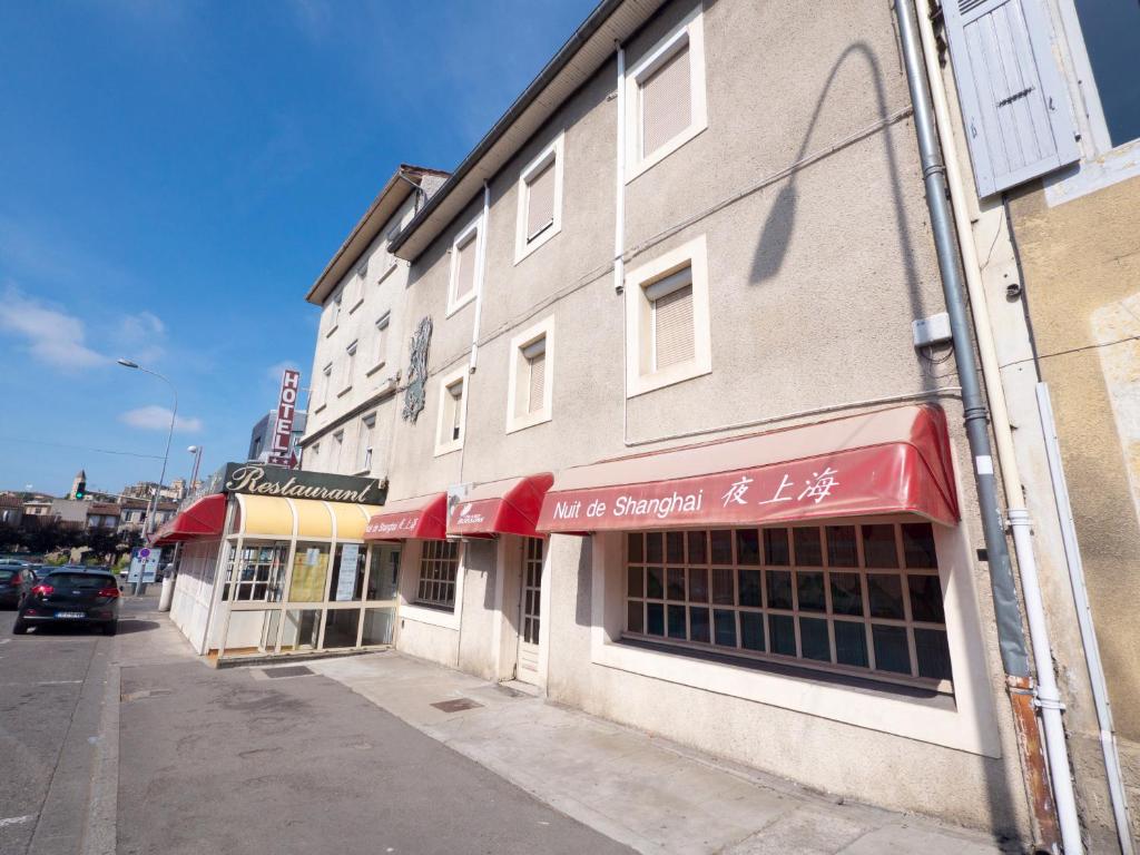 un edificio con un cartel para una tienda en una calle en Le Relais de Gascogne en Auch