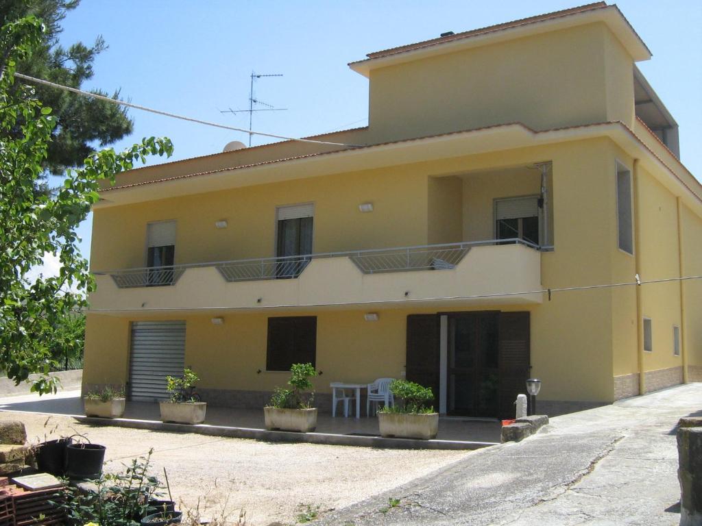 a yellow house with potted plants in front of it at Villa Violetta in Buseto Palizzolo