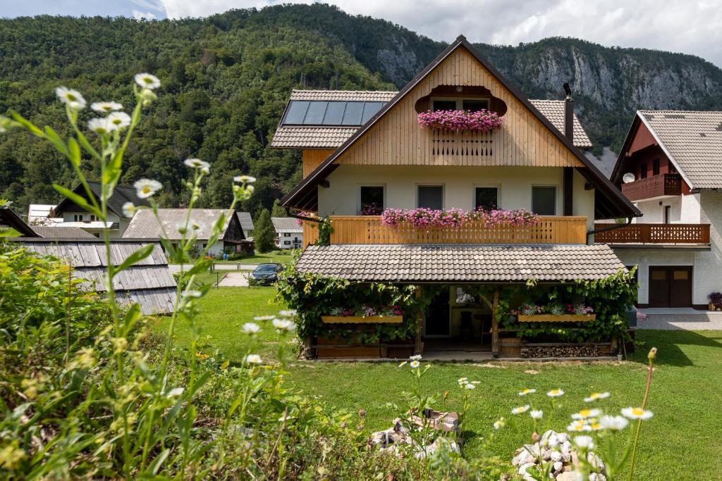 a house with a balcony with flowers on it at TriSa apartments Bohinj in Bohinj