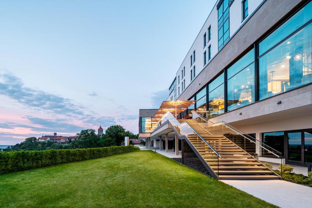 a building with a staircase in front of a yard at Panoramahotel Waldenburg in Waldenburg